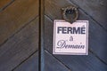 Brown door with a French closed sign